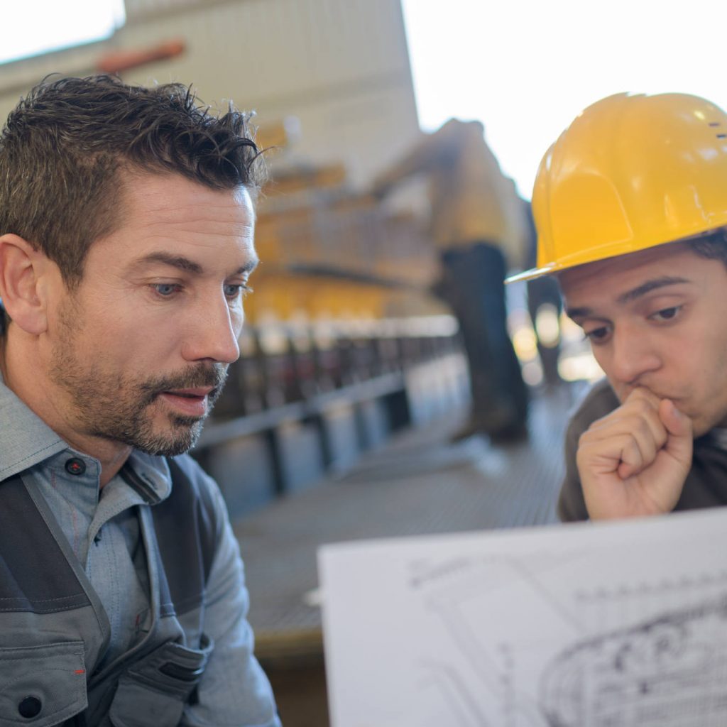male-supervisor-with-worker-discussing-over-bluepr-P6XZSWW.jpg